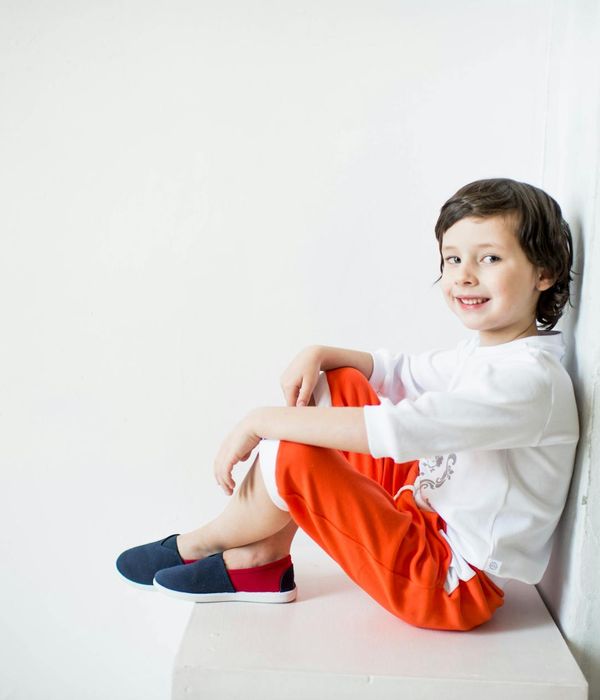 Happy children doing a playful yoga pose in a bright room.
